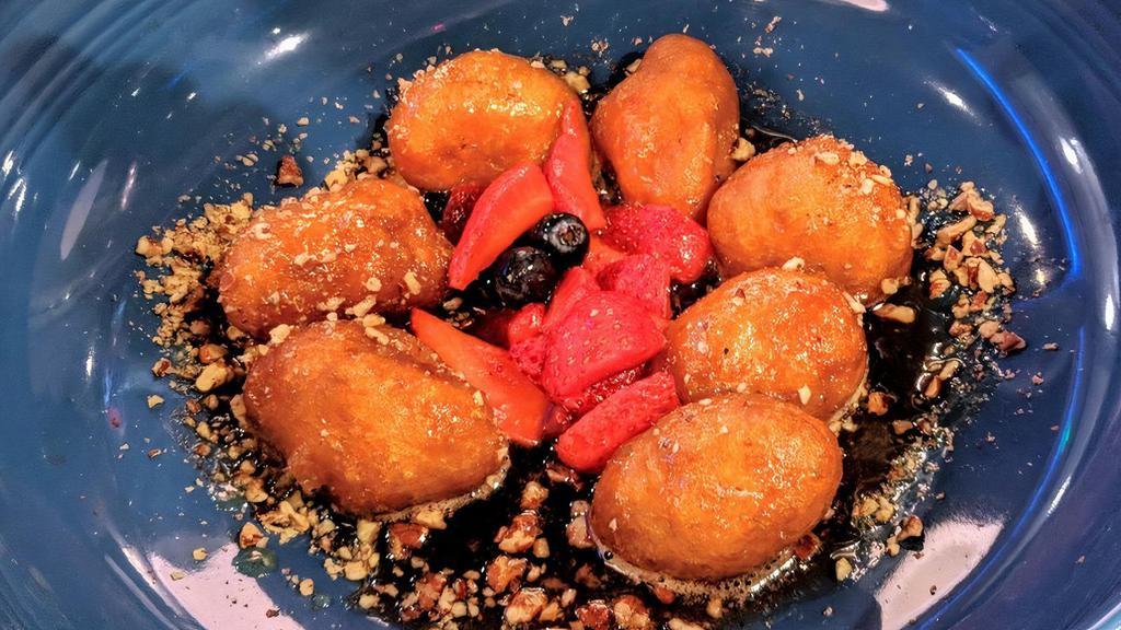 Loukoumades · Rounds of crisp, fried dough tossed in cinnamon & powdered sugar, drizzled with thyme-honey and sprinkled with walnut crumbles.