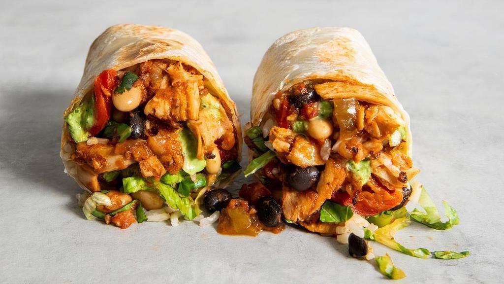 Chick'N  Tinga Burrito · Shredded chick'n, grilled onions, red bell peppers in a spicy roja sauce with brown rice, shredded lettuce, chili beans, queso sauce, green onions, and baja sauce. | 820 cals..