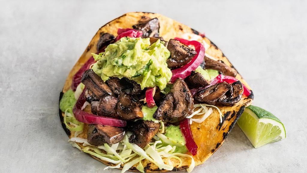 Smokey Mushroom Asada Taco  · Marinated crimini mushrooms topped with shredded cabbage, purple pickled onions, baja sauce, and guacamole and a lime wedge. Gluten-friendly. | 260 cals..