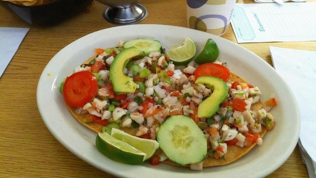 Tostada · Your choice of chicken, ground beef or vegetarian. Open face corn tortilla with your choice of meat, topped with beans, cheese, lettuce, tomato, sour cream, guacamole, mild salsa and cotija cheese.served with beans and rice.