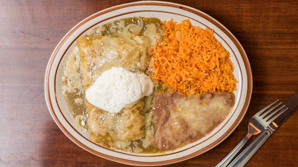 Enchiladas (2) · Your choice of chicken, ground beef or cheese. They are topped with cotija cheese and a special red sauce try them, they are delicious! Served with rice and beans.