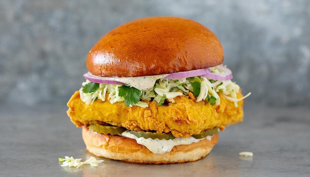 Crispy Tofu Sandwich · Organic tofu from Hodo®, fried crisp and served with green cabbage & cilantro slaw, sliced red onion, dill pickle slices and charred jalapeño mayo all on top of a butter toasted egg bun.