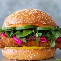 Chicken Schnitzel · Crispy fried chicken breast topped with arugula herb salad, cucumber & pickled turnips on a ...