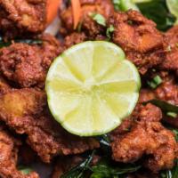 Chicken 65 · Boneless chicken marinated in a spicy masala and deep fried, garnished with onions and lemon.