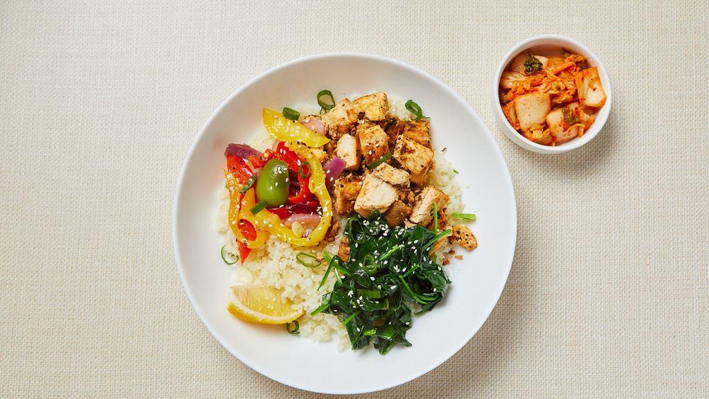 Keto Korean Chicken Bowl · Cauliflower rice, spicy chicken thighs cooked with ginger and sesame oil, served with roasted bell peppers & spinach, sesame seeds, cilantro, lemon wedge and kimchi. Gluten-free. Dairy-free.