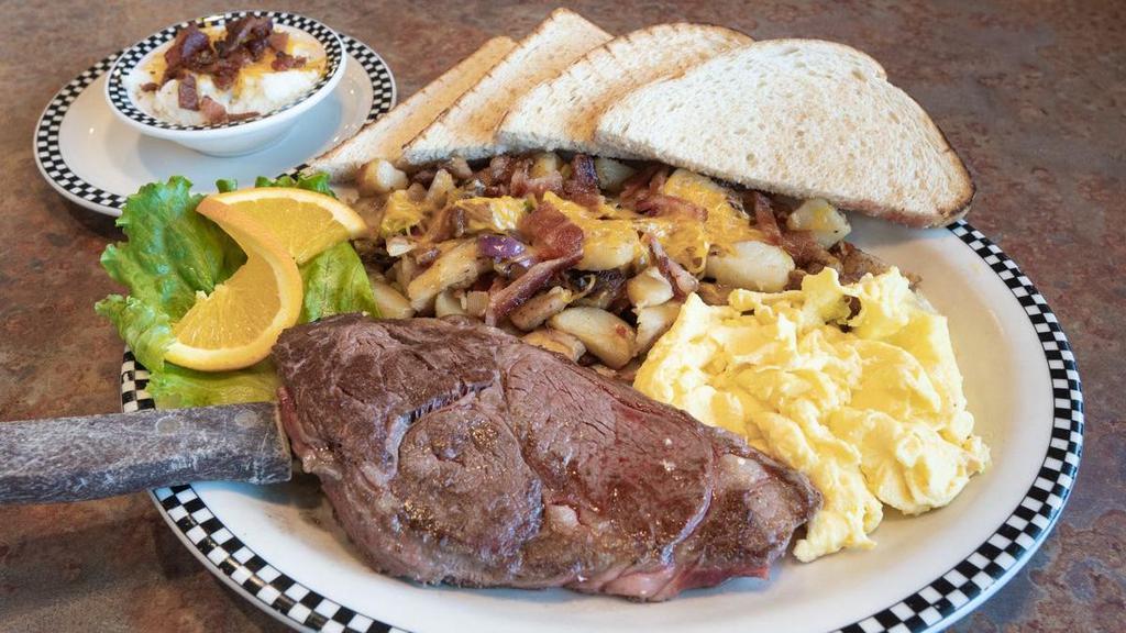 New York Steak & Eggs · 10 oz seasoned Angus Choice cut steak.  Served with cheesy bacon grits, 2 eggs any style, your choice of strip-cut hashbrowns OR country red potatoes and your choice of housemade biscuit OR cornbread muffin.