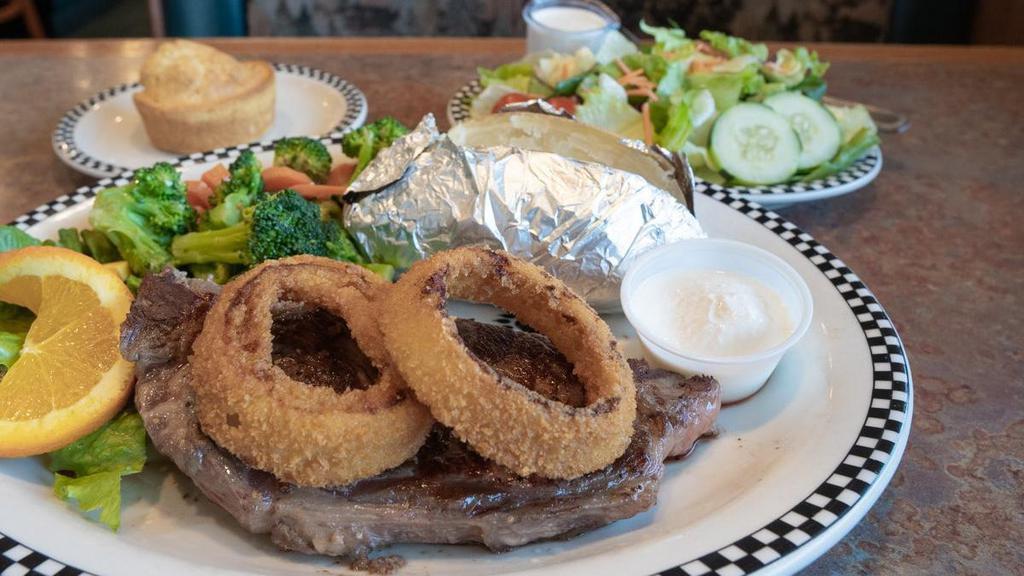 New York Steak* · 10 oz. steak topped with deep-fried onion rings.