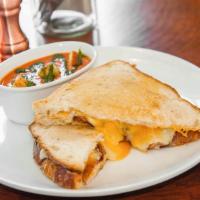 Grilled Cheese · Bacon, aged white Cheddar, yellow Cheddar, and Parmesan cheese, served with a cup of tomato ...