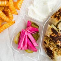 Jordanian Wrap · Chicken shawarma wrap with lavash bread and garlic sauce. On the side are tomatoes, pickles,...
