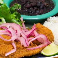 Pescado Frito · Fried fish topped with salsa criolla served with rice, pinto or black beans, organic salad a...