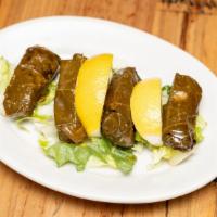 Dolma · Grape leaves stuffed with pine nuts and rice, served with yogurt sauce.