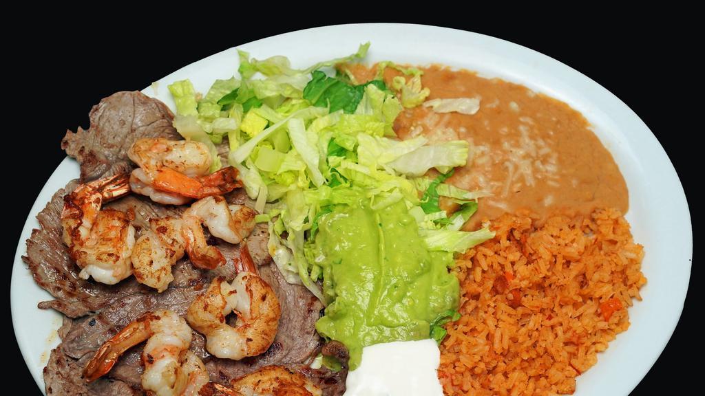 Plato Carne Asada Y Camaron · 2 large pieces of steak topped with pieces of grilled shrimp.