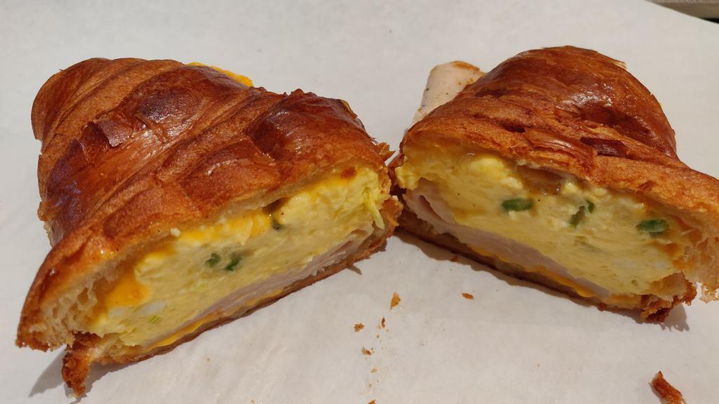 Breakfast Sandwich · Scrambled eggs with melted American cheese on croissant or bagel. Contain dairy, green onion (scallion)