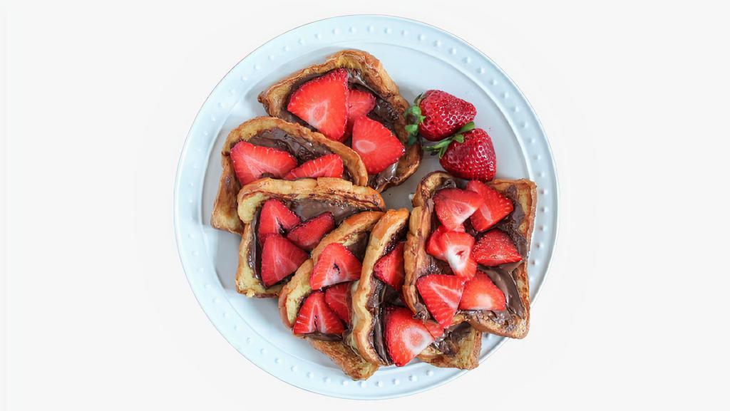 Nutella & Strawberry French Toast · Two classic French toast topped with Nutella and strawberries with syrup on the side.