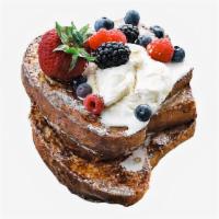 Seasonal Berries French Toast · Two classic French toast topped with seasonal berries and syrup on the side.