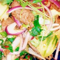 31. Beef Salad · Grilled sliced beef tossed with mint leaves, onions, cilantro, rice powder and in spicy chil...