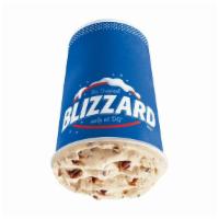 Turtle Pecan Cluster Blizzard® Treat · Pecan pieces blended with chocolate, rich caramel, and creamy vanilla soft serve.
