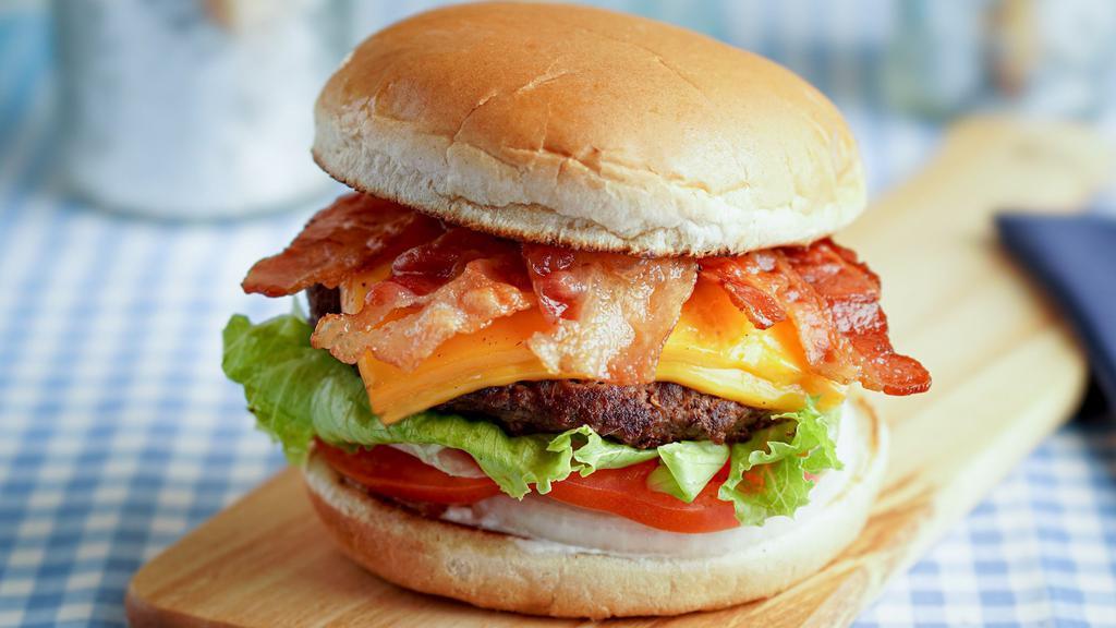 Bacon Cheeseburger · A 1/3 lb. all beef patty served on a toasted bun with tomatoes, lettuce, onions and dressing. Comes with two thick slices of melted cheese and three slices of bacon.