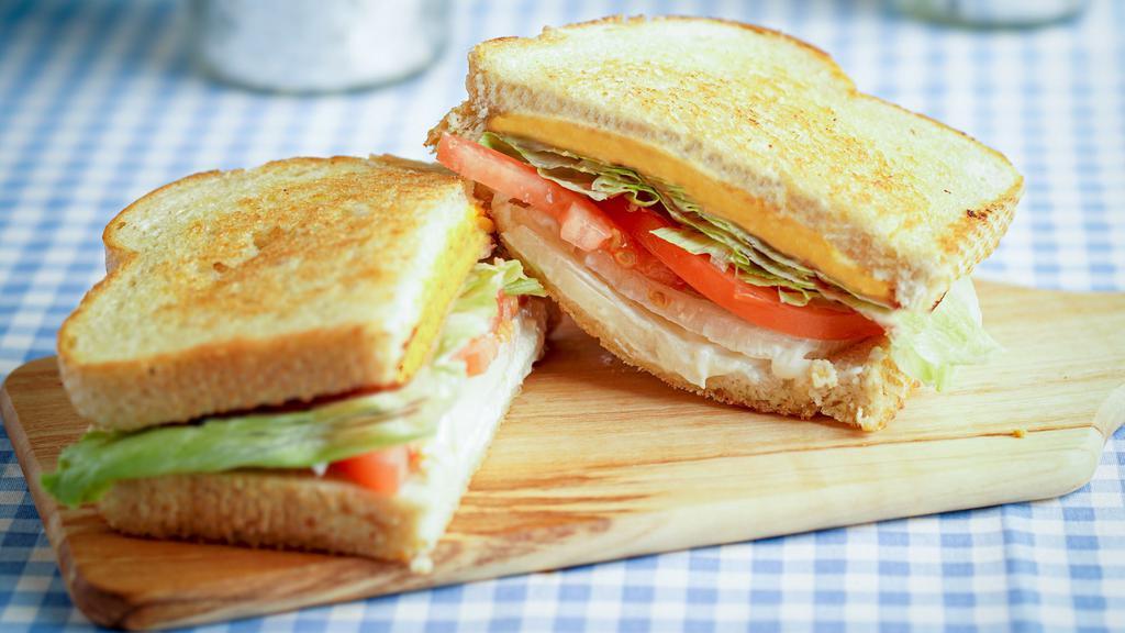 Grilled Cheese · Grilled choice of bread with three thick slices of cheese. Served with everything (tomatoes, lettuce, onion and dressing) or served plain upon special request. *Shown with produce