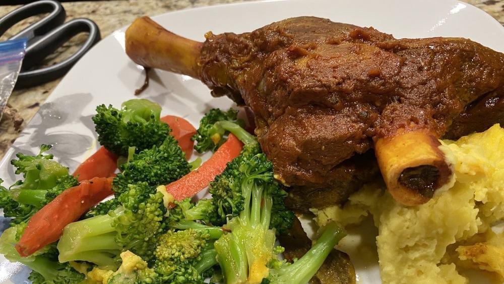 Lamb Shank · Gluten free. Braised lamb shank cooked to perfection in tomato sauce served with roasted garlic mashed potato and fresh garden vegetables.