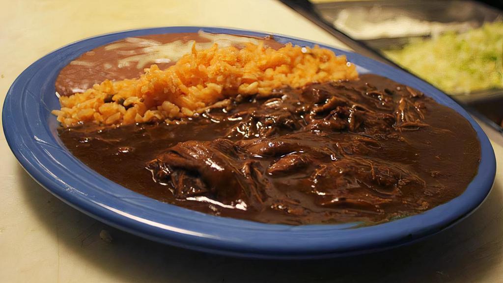Mole Poblano · Shredded Chicken cooked to Perfection in our special Mole Sauce. Served with Rice/Beans and choice of Tortillas.