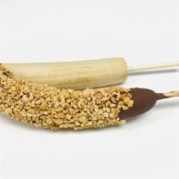 Chocolate dipped frozen banana with peanuts · Ripen frozen banana dipped in chocolate and peanut pieces.