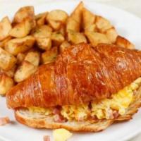 Croissant Sandwich Breakfast · 2 eggs scrambled with ham and Cheddar cheese in a warm croissant. Served with potatoes.