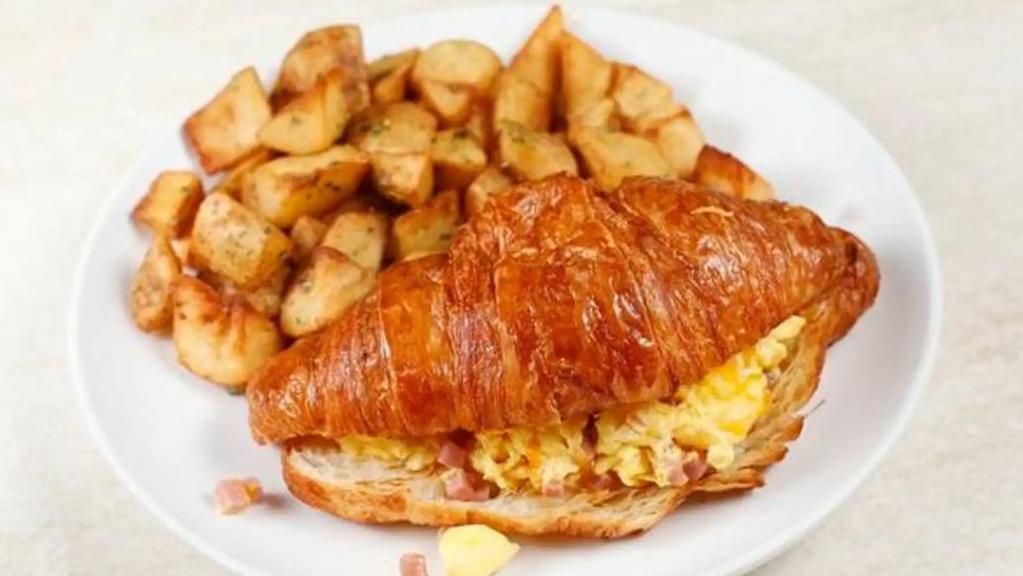 Croissant Sandwich Breakfast · 2 eggs scrambled with ham and Cheddar cheese in a warm croissant. Served with potatoes.
