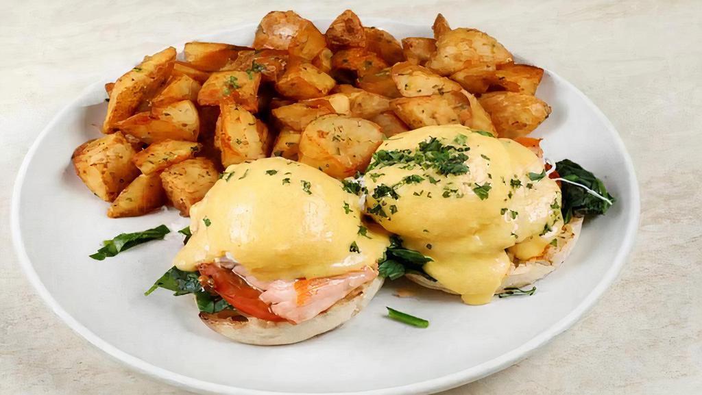 Salmon Benedict Breakfast · 2 poached eggs, salmon, tomato, served on an English muffin, topped with hollandaise sauce, and served with potatoes or salad or fruit.