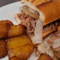 Pan con Lechon · Marinated slow roasted pork. Topped with grilled onions.
