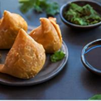 Samosa Cravings (3) · Three samosas, crunchy savory pastries stuffed with spicy potatoes and peas. Served with zin...
