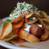 Dirty Dog · bacon-wrapped nathan’s hot dog in a bun, topped with potato chips, blue cheese dressing, buf...
