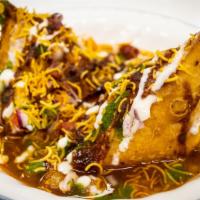 Samosa Chaat · Samosas in chickpea gravy topped with vegetables and chutney