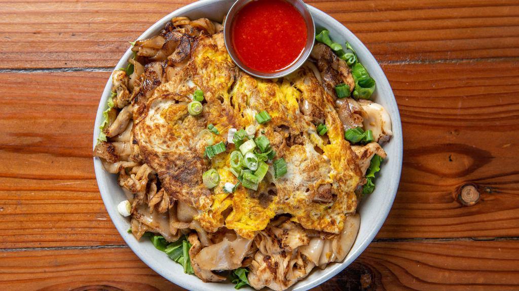 Kua Gai  · Wok toss flat rice noodles, egg, chicken, calamari, shrimps, green onions. served over green leaves & shiracha sauce.