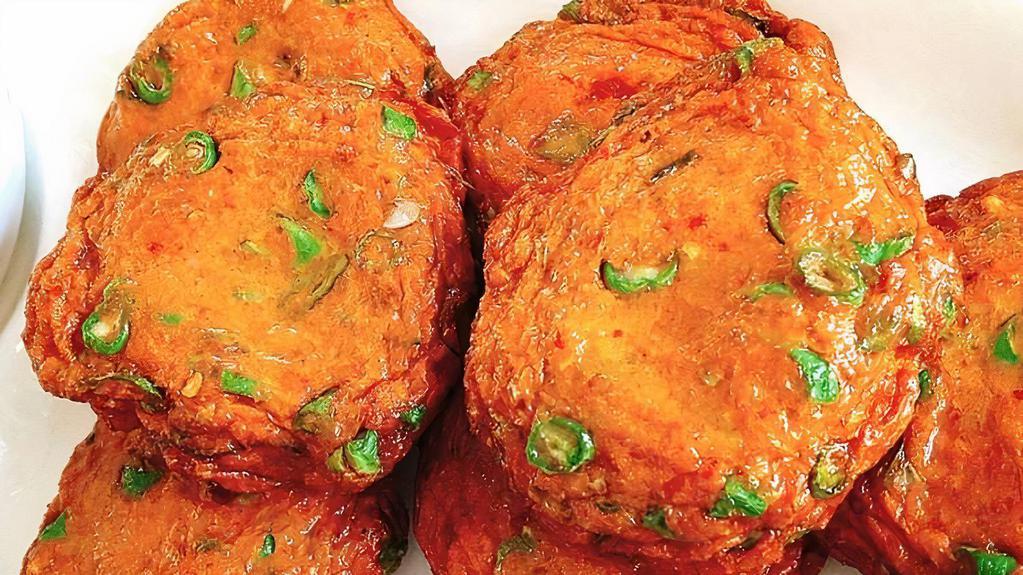 A3. Thai Fish Cake · Fish cake patties seasoned with curry paste, kaffir lime leaves and green bean served with sweet chili cucumber sauce. Topped with ground peanuts.