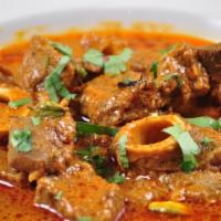 Goat Curry · Chef special goat cooked with onion garlic and Indian spices .