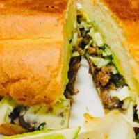 Super Torta · Meat, fried beans, cheese, avocado, lettuce, onions, cilantro, jalapeños and sour cream.