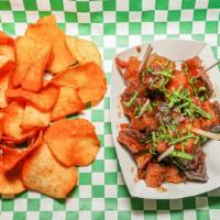 Pork Belly Bites · Pork belly bites tossed in a cherry bourbon Bbq sauce, served with yuca chips.