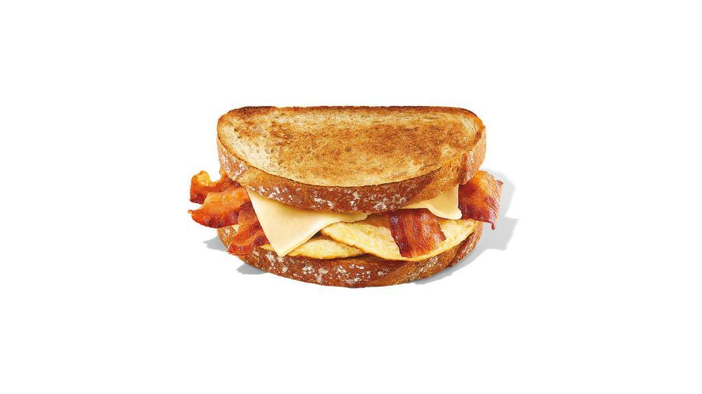 Sourdough Breakfast Sandwich · Two eggs, five half slices of bacon and white cheddar on two pieces of sourdough toast.