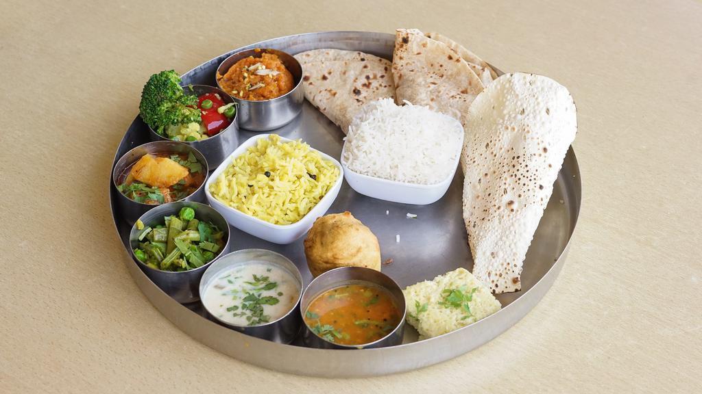 Rajwadi Silver Thali · Fixed meal of 3 Vegetable Curries of the day + Gujarati Surti Dal + Gujarati Surti Kadhi + Roti (3 pcs.) + Rice + Khichdi + 1 Dessert of the day.