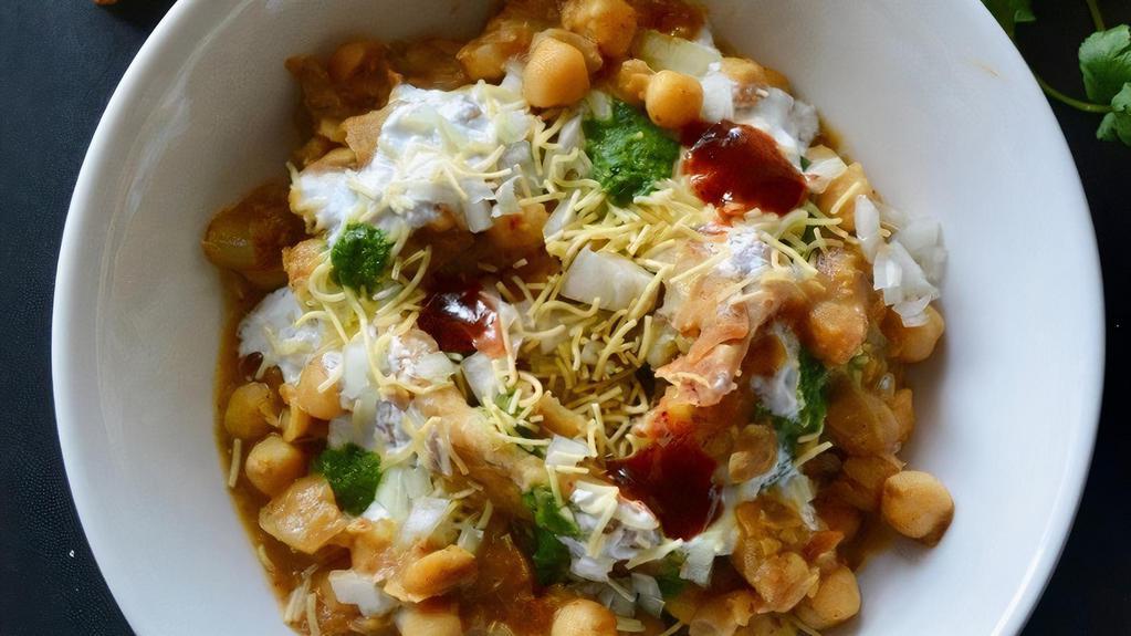 Samosa Chaat · Triangular Crispy Shell stuffed with Spiced Potatoes topped with chana curry, sweet and spicy Chutneys and onions.