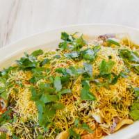 Sev Papdi Chaat · Round flat crispy wafers topped with potato, chickpeas and sweet/spicy Chutneys sprinkled wi...