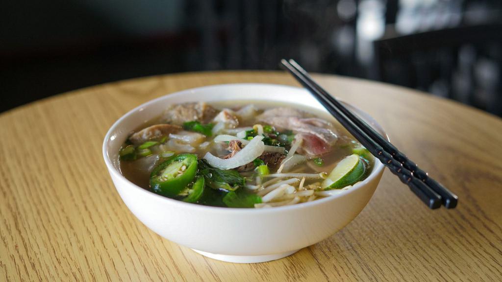 Rare Steak & Tendon Phở · Beef Fillet mignon slices, beef tendon, beef broth noodles soup. also come with side of vegetables (Basil, Cilantro, Bean Sprout, Lime)
sauce: Sriracha, Hoisin sauce