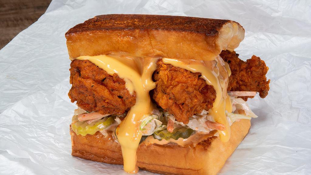 The Cheesy Chick · 2 crispy fried chicken tenders, spiced to your liking: plain, nashville hot or nashville hotter; with dill pickle slices, slaw, white american cheese, cheese sauce and chipotle aioli; served on king's hawaiian rolls