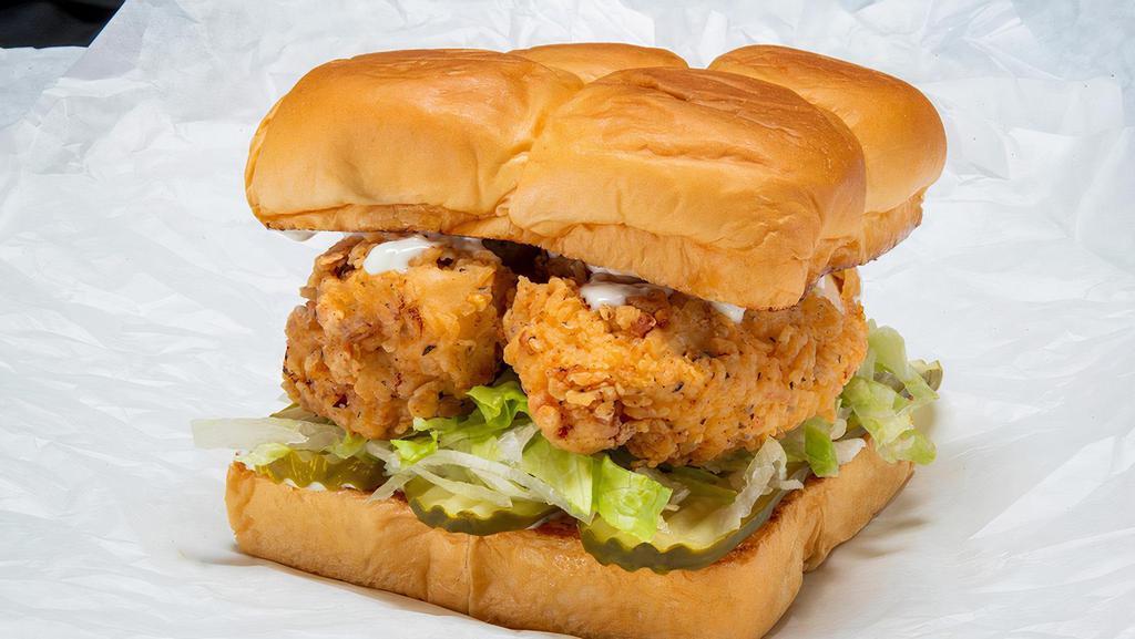 Bad Mutha Clucka · Two crispy fried chicken tenders, spiced to your liking, Plain, Nashville Hot or Nashville Hotter with miso ranch, dill pickle slices and lettuce; served on Kings Hawaiian rolls