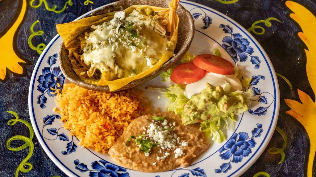 Pork Tamales Plate · Corn dough with corn oil in a corn husk stuffed with peppers, onions and tomatoes topped with pork and chile verde sauce, and melted cheese. Served with rice, choice of beans and salad.