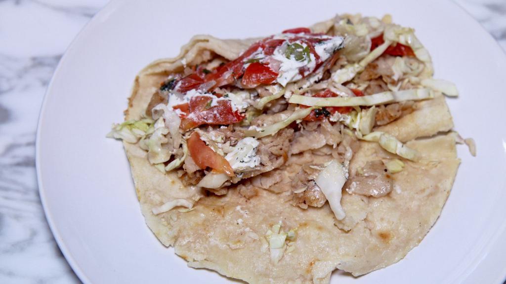 Fish Taco · Corn tortillas, fish, onions, cilantro, and sauce.