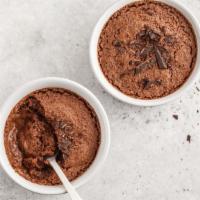 Mousse al cioccolato · A chocolate sponge base tp[[ed with a dark chocolate mousse and dusted with cocoa powder.