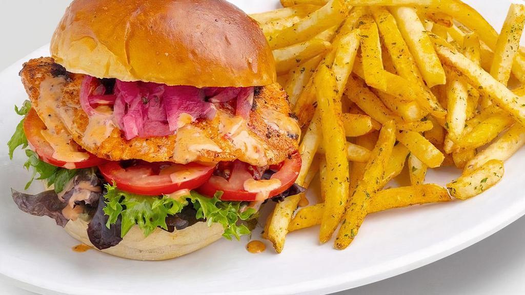 Norwegian Salmon Sandwich · Grilled Brioche Bun, Mixed Greens, Tartar Sauce & Dynamite Sauce, Tomatoes, Pickled Onions. Accompanied with choice of side.