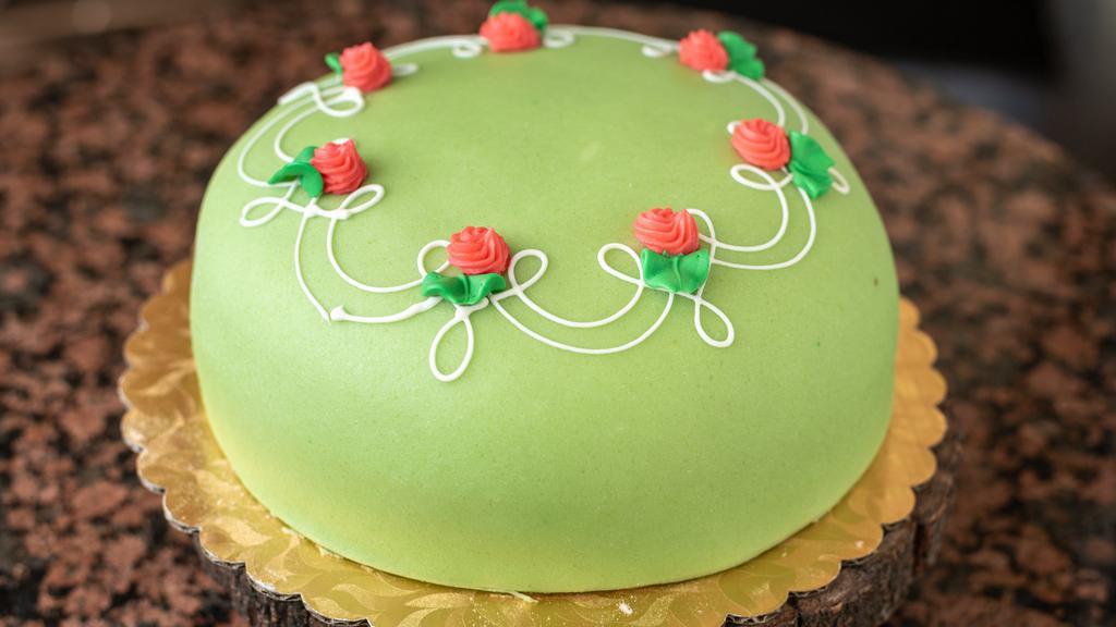 Princess cake · One of our most popular cakes. Moist sponge layers brushed with an orange simple syrup in between is a thin layer of raspberry preserves, Italian pastry cream, and fresh whipped cream. This cake is then covered in almond paste.